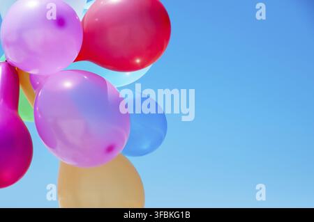 Multicolored balloons against the blue sky, close up Stock Photo