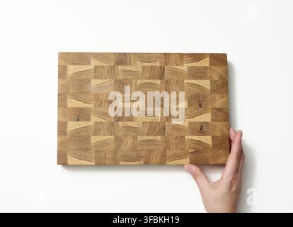 Female hands hold empty rectangular brown wooden chopping board on white background Stock Photo