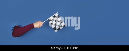Hand holding checkered flag over blue background, panoramic layout Stock Photo