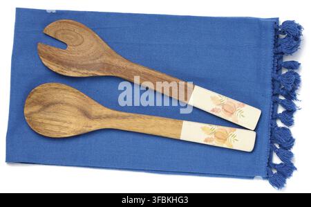 Two wooden spoons on a blue textile kitchen towel, top view Stock Photo
