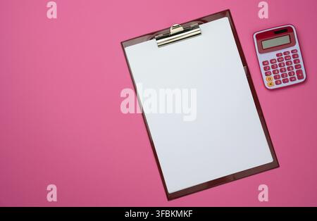 Plastic pink calculator and folder with blank white sheets on pink background, top view Stock Photo