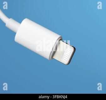 White lightning cable on a blue background, close up Stock Photo