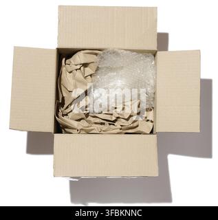 Open cardboard box, inside crumpled paper and polyethylene, top view Stock Photo