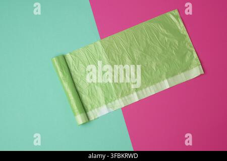 Green transparent plastic bag for garbage on a colored background, top view Stock Photo