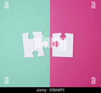 White large blank puzzles on a pink green background, top view, copy space Stock Photo