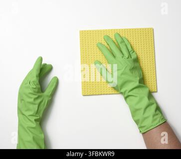 Two female hands in rubber protective gloves for cleaning hold a yellow spond on a white background Stock Photo