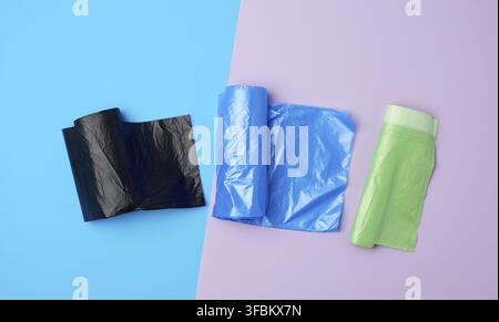 Three rolled up rolls with plastic garbage bags on a blue background Stock Photo