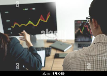Working business man, team of broker or traders talking about forex on multiple computer screens of stock market invest trading financial graph charts Stock Photo