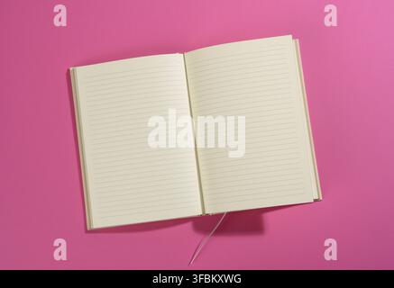 Open notebook with blank white sheets on pink background, top view Stock Photo