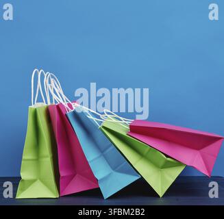 Multicolored paper bags with a handle for shopping and gifts on a blue background Stock Photo
