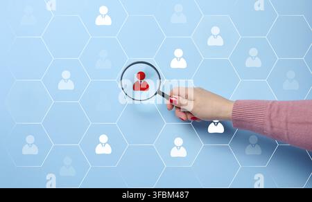 Search and selection of personnel in the company. Effective personnel management, leader identification. Magnifying glass and staff icons on blue back Stock Photo