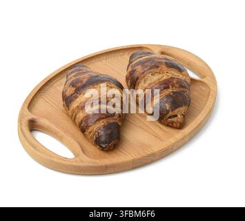 Two baked croissants lie on a wooden tray, food isolated on white background Stock Photo