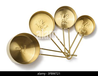 Golden metal measuring spoons for bulk and liquid products on a white isolated background, top view Stock Photo