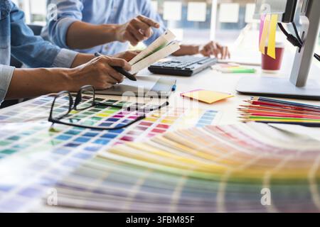 Professional Creative architect graphic desiner occupation choosing the Color pantone palette samples for project on office desktop computer Stock Photo