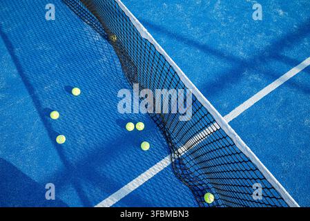 Overhead perspective of a sports facility featuring a net and tennis balls on a textured blue ground Stock Photo