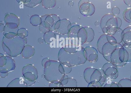 Beautiful round soap bubbles in the air, blue sky with pretty soap bubbles, soap bubbles of different sizes float in the air with a blue sky Stock Photo