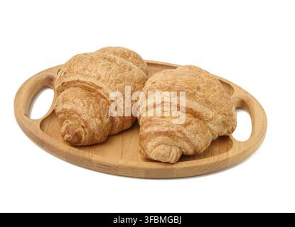 Two baked croissants lie on a wooden tray, food isolated on white background, top view Stock Photo