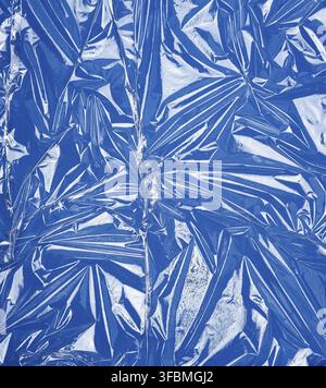 Texture of a transparent stretching plastic film for packaging products on a blue background, full frame, close up Stock Photo
