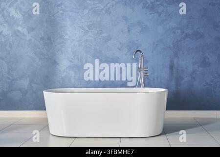 A modern white bathtub against a blue textured wall with room to copy. Tiled floor in bathroom interior. An empty background for your design. Stock Photo