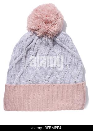 Gray-pink knitted hat with a pom-pom on a white isolated background Stock Photo