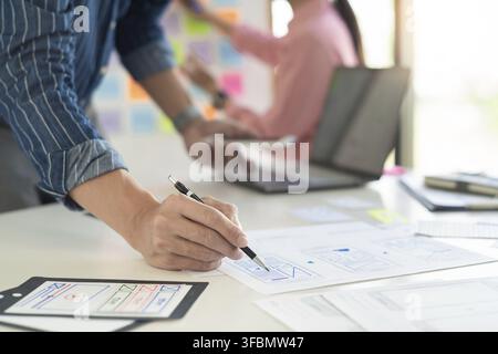 Graphic designers team work together with UX UI designer planning application template layout mobile phone prototype, User experience concept Stock Photo