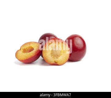 Ripe red whole and halves of plum isolated on white background, close up Stock Photo
