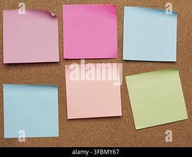 Colorful paper stickers glued on brown balsa board, idea and multitasking, close up Stock Photo