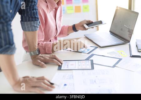 Graphic designers team work together with UX UI designer planning application template layout mobile phone prototype, User experience concept Stock Photo