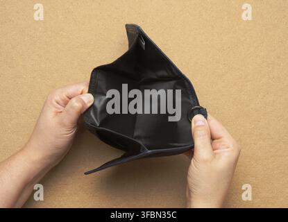 Female hands hold blue open empty wallet for cash, top view Stock Photo