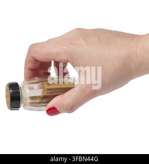 Female hand holding container with ground cinnamon on isolated background Stock Photo