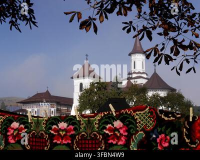 Bright, traditional rugs with painted monastery in background, Romania. Ample copy space. Stock Photo