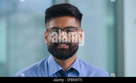 Close up confident optimistic Indian Muslim businessman smiling looking at camera in marketing agency Arabian business man in glasses smile happy in Stock Photo