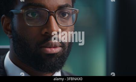Close up African American business man serious looking in computer monitor in office. Portrait ethnic businessman male guy executive employer Stock Photo
