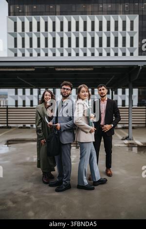 Business team of young professionals standing confidently on an urban rooftop near office building Stock Photo