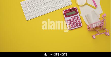 White wireless keyboard, stack of paper receipts and magnifier on yellow background, budget analysis concept, savings. Copy space Stock Photo