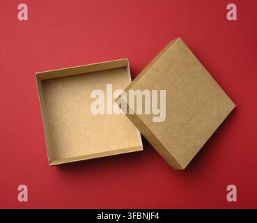 Empty square brown box on a red background, gift open, top view Stock Photo
