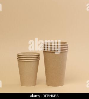 Stack of brown paper disposable cardboard cups on beige background Stock Photo