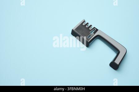 Manual sharpener for kitchen knives on a blue background, copy space Stock Photo