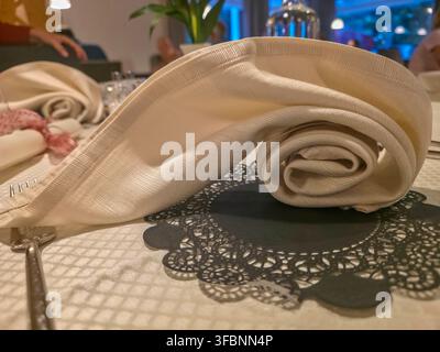 An Elegant Folded Napkin on Patterned Beige Tablecloth for Wedding and Banquet Table Setting Stock Photo