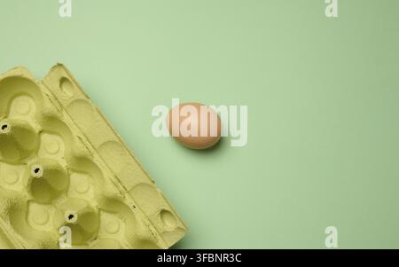 Egg box with egg on green background, space for text Stock Photo - Alamy
