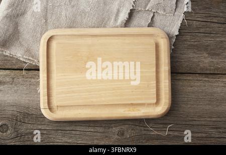 Light beige rectangular empty cutting kitchen board on a wooden background from old boards, top view Stock Photo