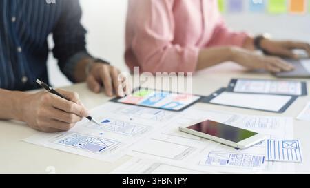 Graphic designers team work together with UX UI designer planning application template layout mobile phone prototype, User experience concept Stock Photo