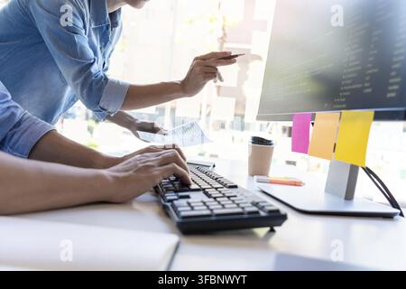 Pensive programmer working on on desktop pc programming code technologies or website design at office Software Development Company Stock Photo