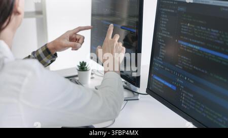 Young startup Programmers Sitting At Desks Working On Computers screen for Developing programming and coding to find solution to problem on New Applic Stock Photo