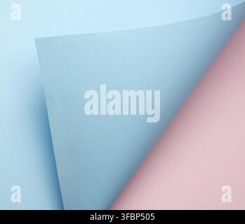 Curled blue sheet of paper on pink background, abstract background, close up Stock Photo
