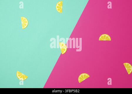 Abstract green-pink background with paper yellow lemon slices, close up Stock Photo