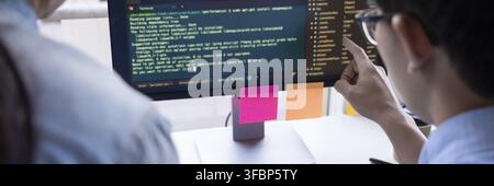 Young startup Programmers Sitting At Desks Working On Computers screen for Developing programming and coding to find solution to problem on New Applic Stock Photo