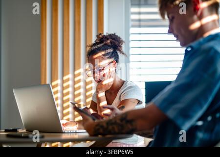 University students working together on laptop during study session. Stock Photo