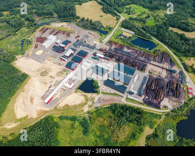 Aerial view of a forest clearing with stacks of freshly cut timber and ...