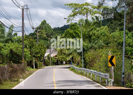 TUBKAEK BEACH, THAILAND — FEBRUARY 18, 2026: A local road curves through dense tropical vegetation in the Nong Thale area of Krabi Province. Stock Photo